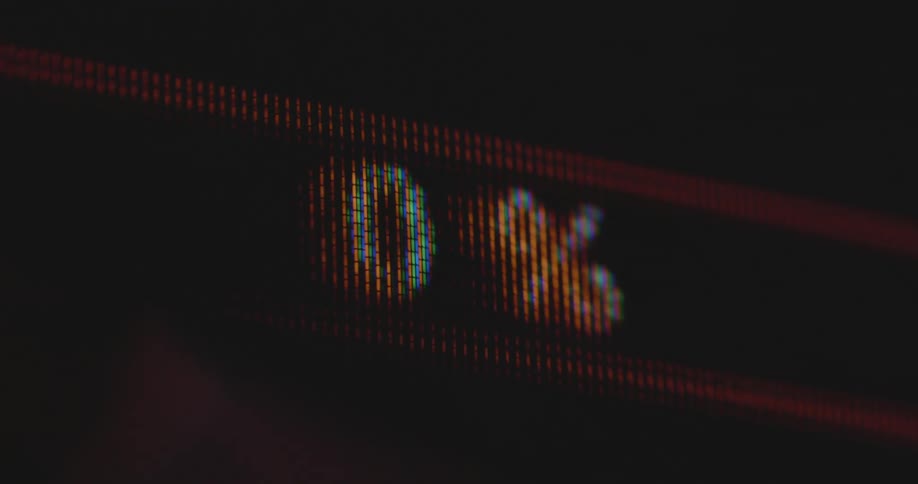 Macro close-up of a TV screen with rgb pixels displaying the loading or scanning process of an Artificial Intelligence or search algorithm with a measurement in percent as the counter or meter reaches one hundred % then goes down to zero