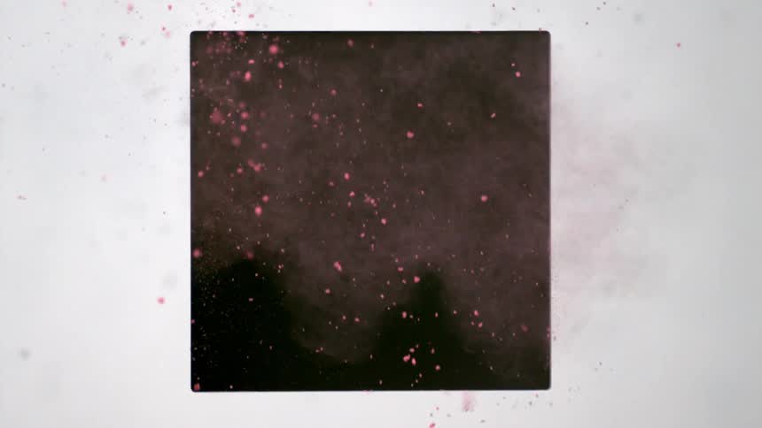Pink powder blows down and out of a square cut in a panel