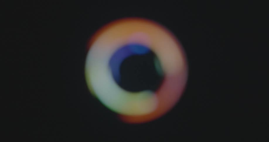 Abstract footage of multicolored out of focus neon light balls or spheres spinning around forming bokehs in the LGBTQ+ rainbow colours green red orange yellow blue purple lilac and pink