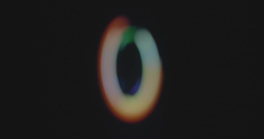 Multi-colored and colorful bokehs in the colors of the LGBT and LGBTQ community promoting same sex love forming a spinning processing circle on a retro television or computer monitor with pixels