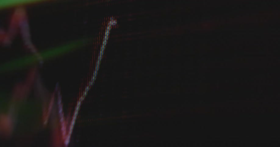 Computer program creates a red line graph on a PC monitor going up and down and falling after being rejected by the trend line as a symbol for financial meltdown and losing money in the stock and crypto investment market
