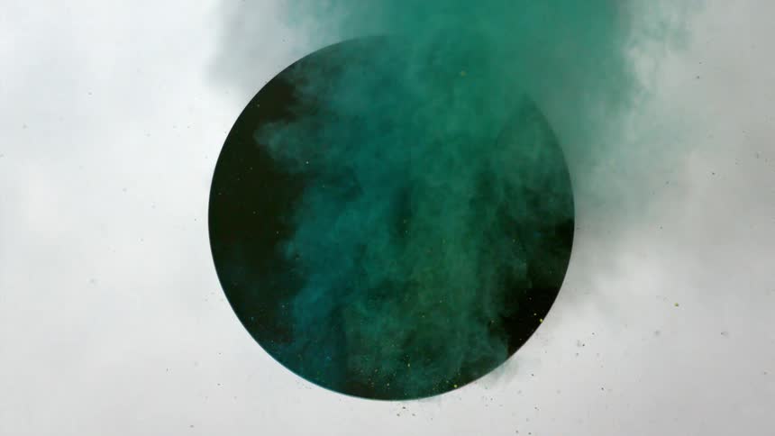 Green dirt flies through a black circle