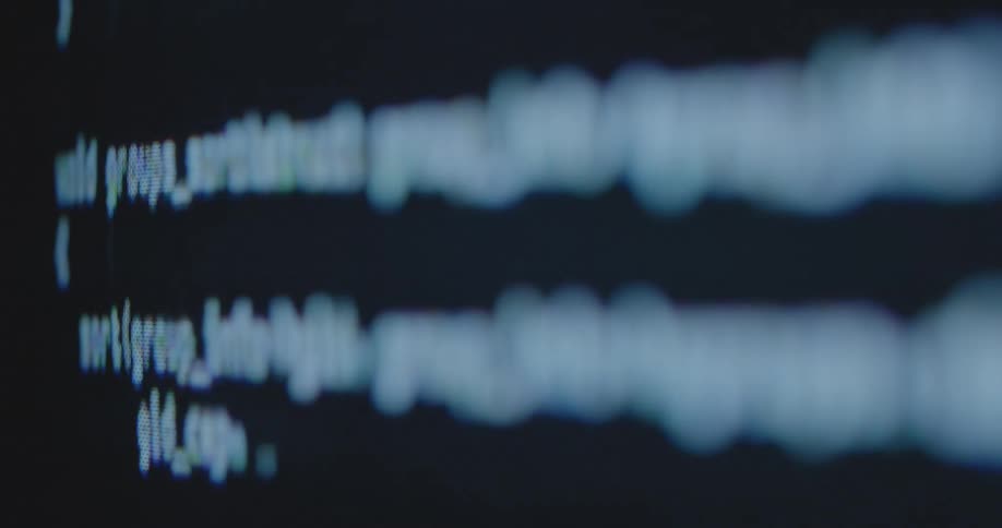 Unrecognisable coding or programming text in an encrypted computer language such as HTML or Javascript is automatically appearing on a pixelated 90s computer terminal display device during system startup or booting process