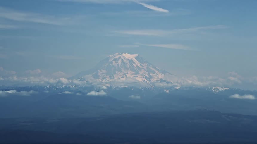 Aerial footage of snow-capped Mount Rainier in the Cascade Range Washington showcasing the breathtaking natural beauty of the Pacific Northwest during summer
