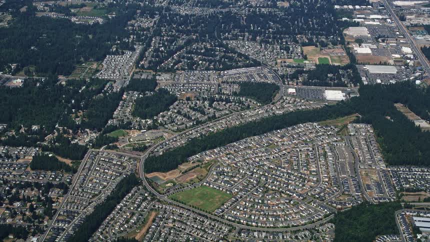 Reverse aerial view of sunny suburban neighborhoods in Renton Washington showcasing the beautiful residential area during a summer day