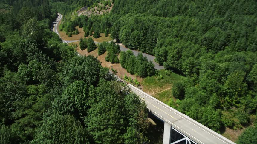 An SUV crosses the Spirit Lake Highway bridge in Cowlitz County Washington during daytime aerial footage