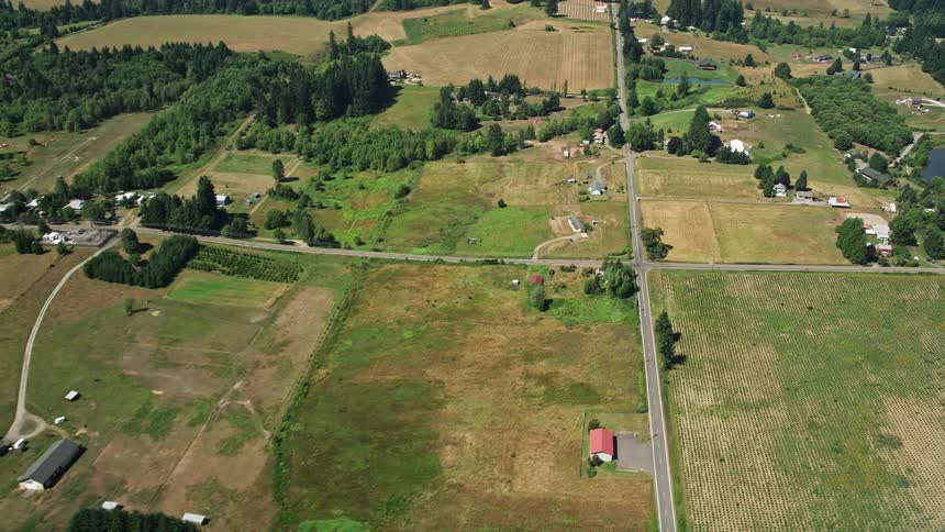 Aerial footage of scenic rural landscape in La Center Washington showcasing small farms fields and picturesque country roads on a sunny summer day