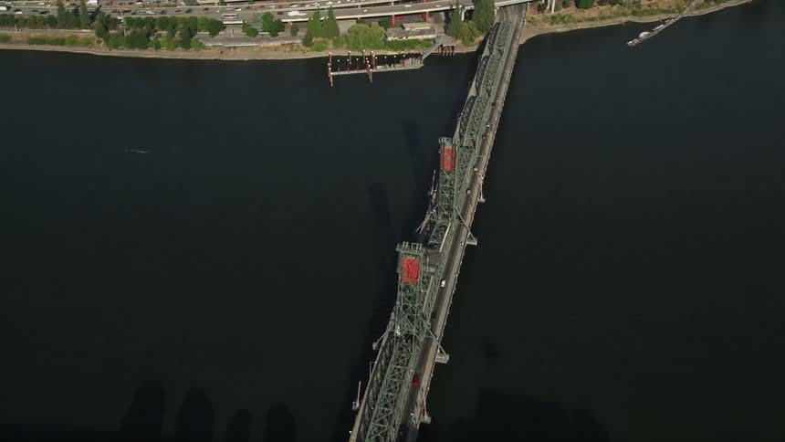 Aerial view of the Steel Bridge spanning Willamette River in Downtown Portland Oregon with cars passing and the cityscape in the background