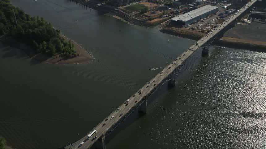 Aerial footage of Ross Island Bridge revealing downtown Portland cityscape over the Willamette River during a sunny summer day