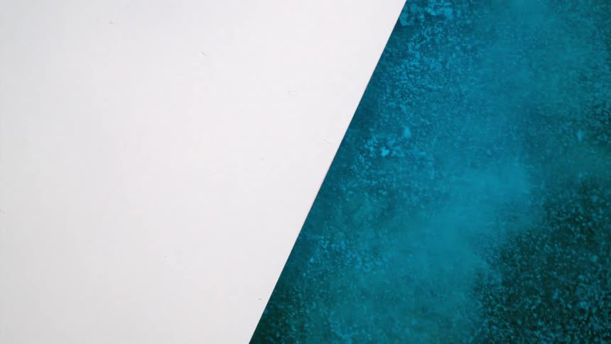 Blue dirt pours out of a black area