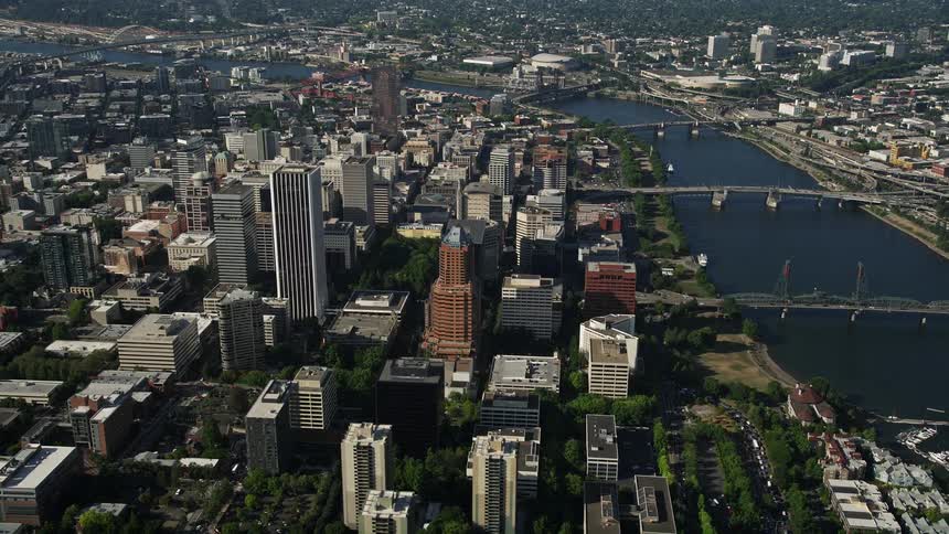 Aerial view of downtown Portland Oregon with multiple bridges crossing the river near the marina on a sunny day during summer