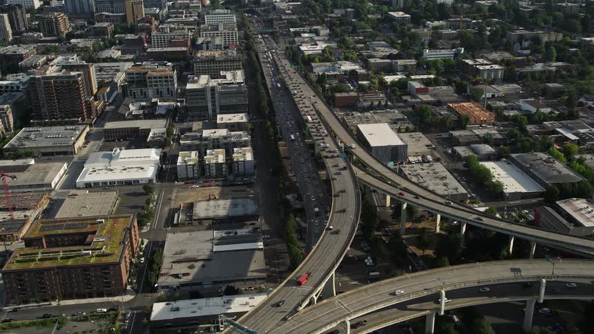 Fly over heavy traffic on Interstate 405 and Highway 30 in downtown Portland Oregon during a sunny day