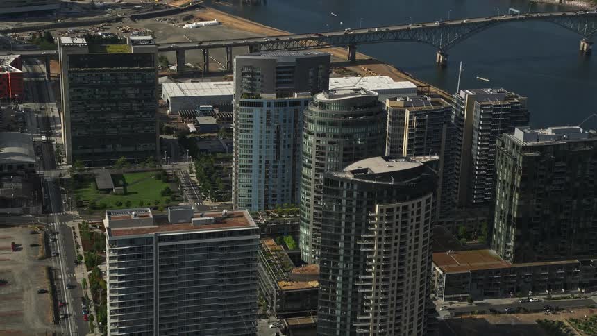 Aerial footage of South Waterfront Portland Oregon during a sunny day showcasing condominium high-rises and the beautiful Willamette River