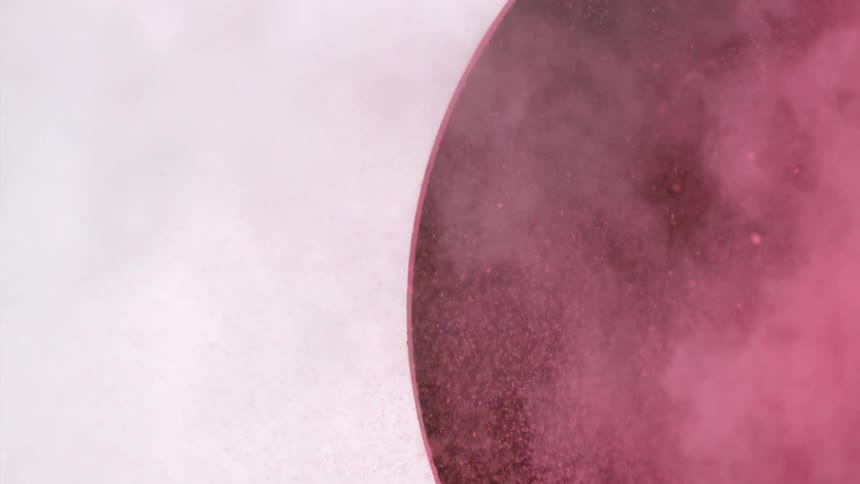 Pink powder shooting out of a circular hole in wall
