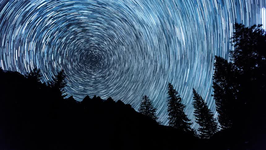 The stars spin above a forest