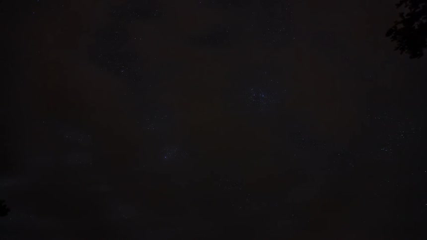 Lights and clouds move across a starlit sky
