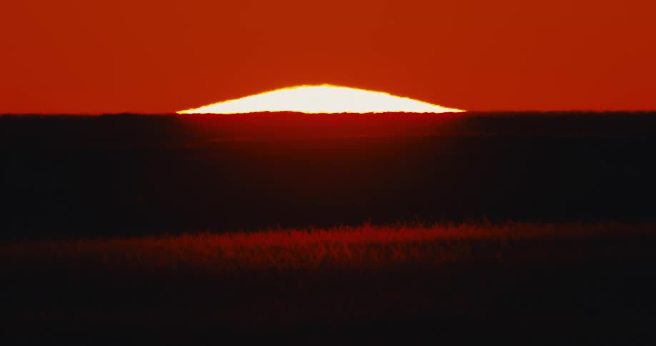 Sun rising in a stark red sky