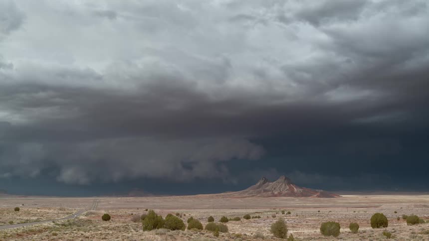 A lightning storm in the desert with a mountain in the landscape