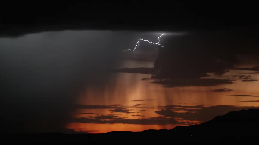 A view of some lightning falling in the dark field in a night with orage sky