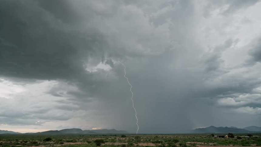 Lightning storm with cloudy sky with mountains on the horizon