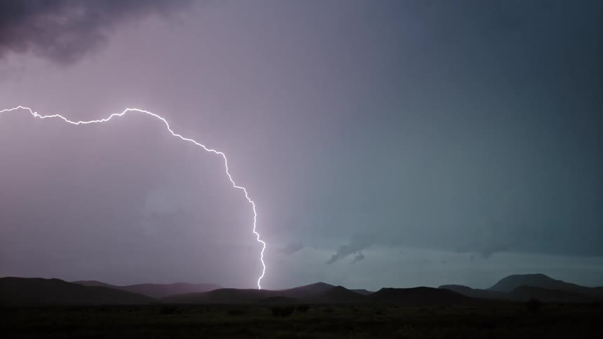 A storm in the horizon of a landscape at night