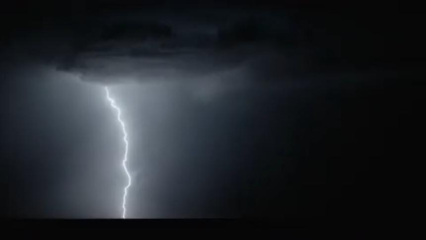 Lightning striking the ground in the middle of the night lighting up the night sky