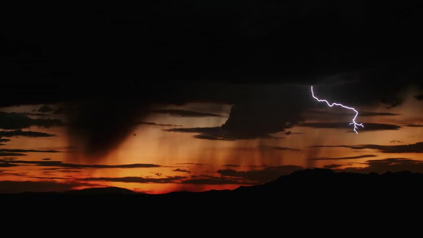 A lightning storm crashing into a dark orange sky