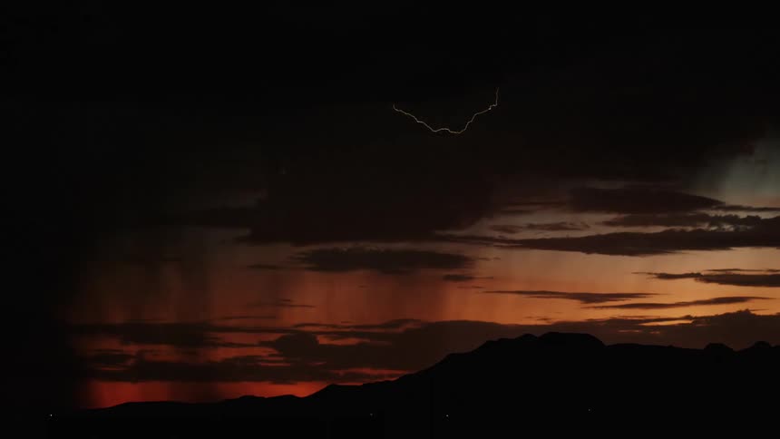 White lightning and thunder slicing through the sky at sunset