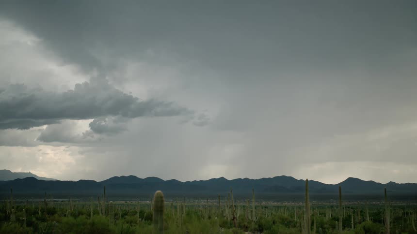 A stormy sky with lightning and dark clouds near mountains in the desert
