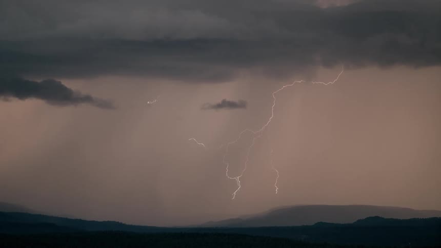In the evening lightening strike as the cloud becomes red in the valley