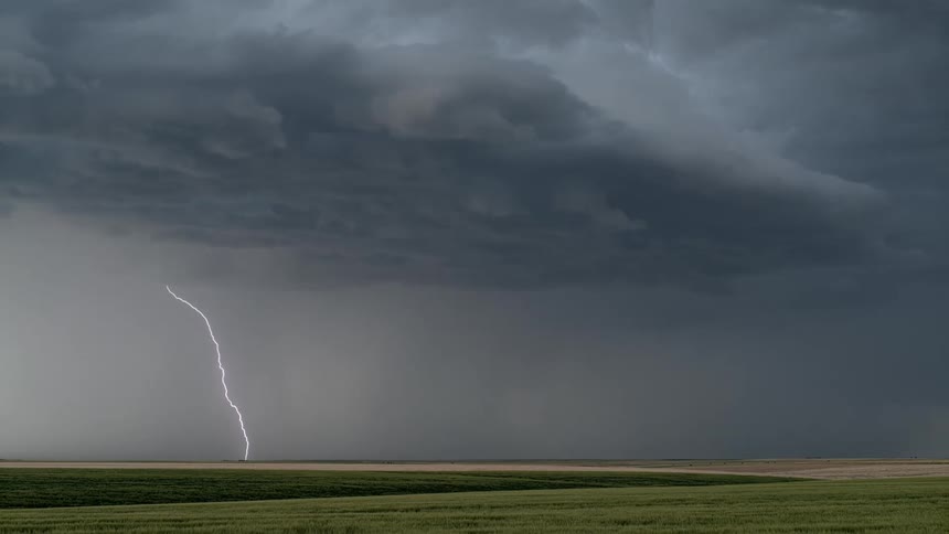 A dark sky with lightning above a field