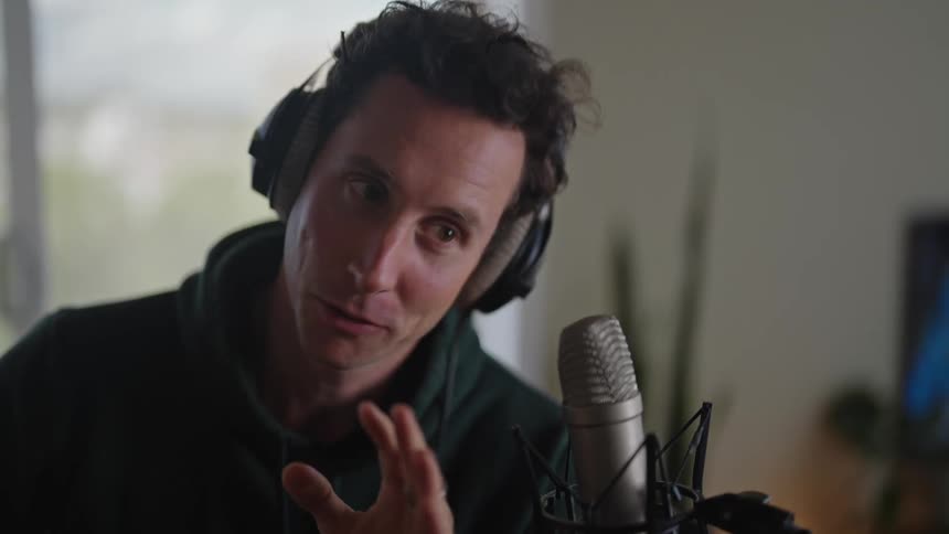 A man is talking into a microphone for a podcast