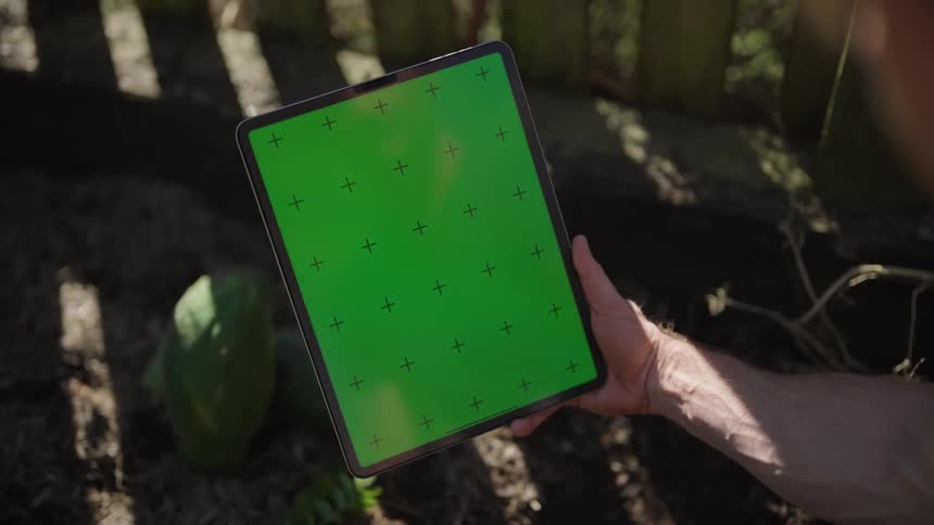 Person holding a tablet with green screen
