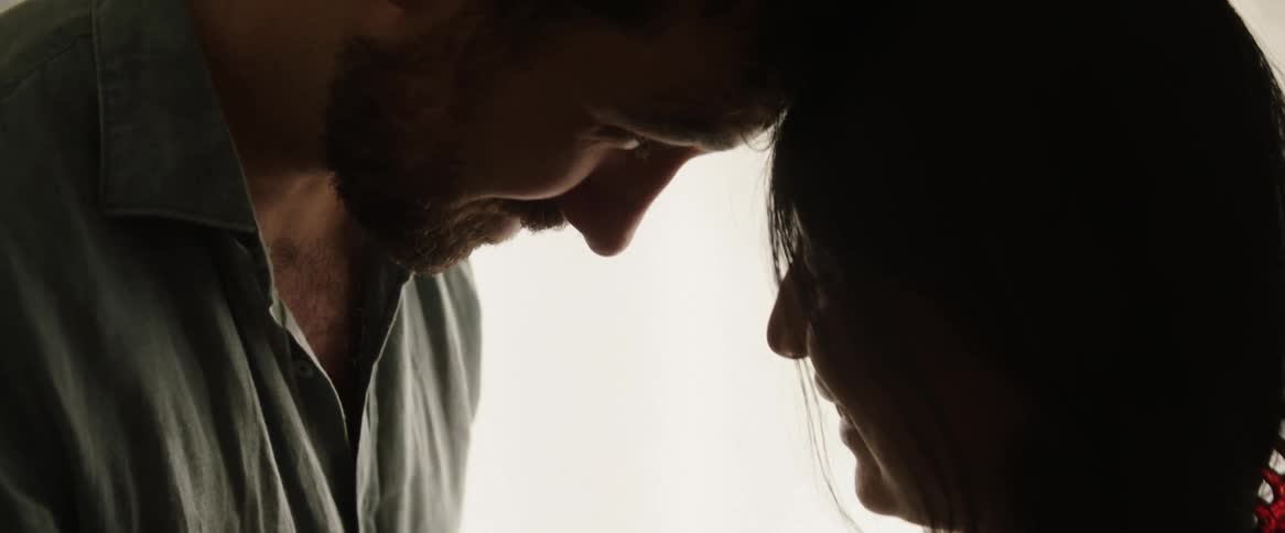 Father and mother smiling while watching their new born baby