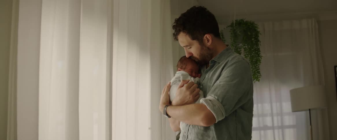 Father holding and hugging his baby son and kissing