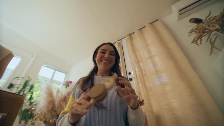 Woman smiles while sitting on floor and playing with toys in home