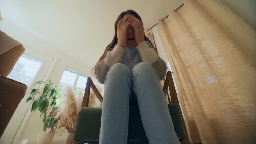 Woman sitting on chair making hand gestures and talking and smiling in a playful way