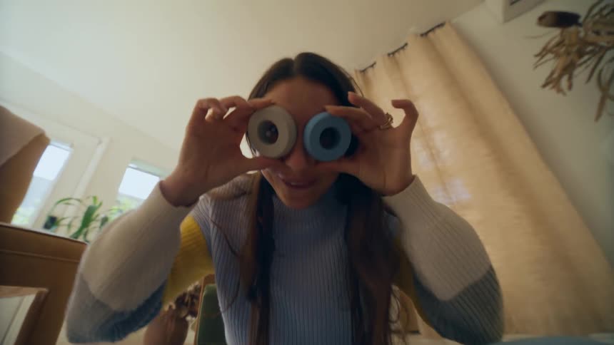 Woman putting round shapes on her eyes in a funny way