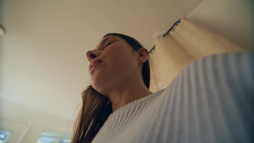 A mother looks down at the infant she is holding with a reassuring smile