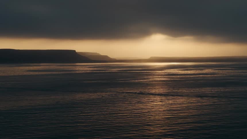 Sunset over the mountains and the calm sea