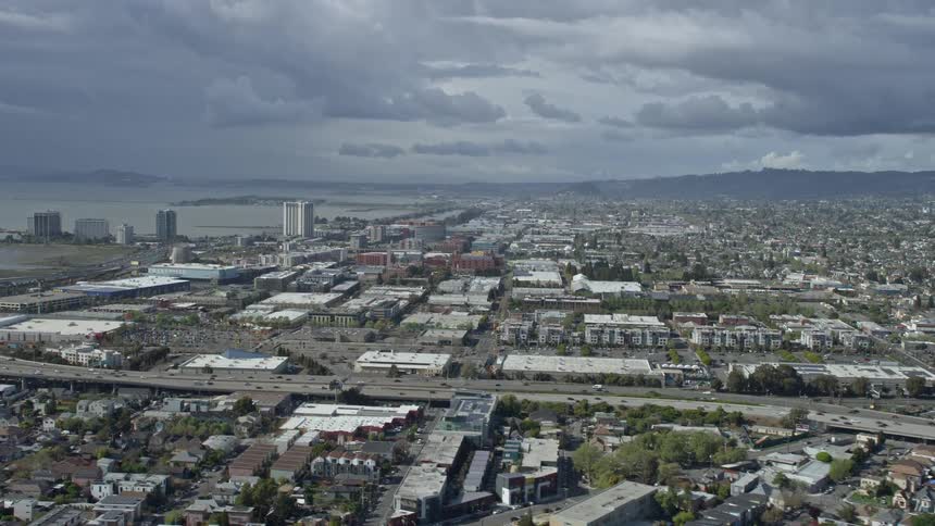 Aerial footage of Emeryville California showing a shopping mall and apartment buildings on a partly cloudy day