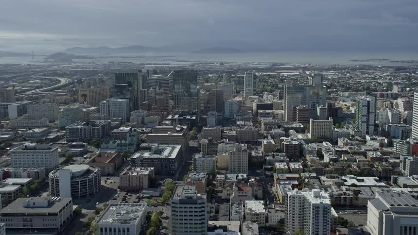  aerial footage showcasing the bustling downtown office buildings of Oakland California against a partly cloudy backdrop filmed with a Shotover F1 camera during the summer season