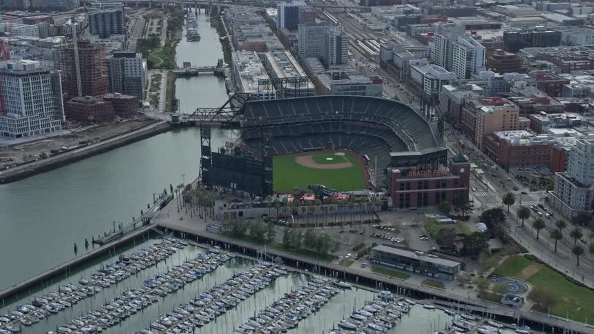  aerial footage of a baseball stadium in the South of Market district of San Francisco California showcasing a cityscape backdrop and cloudy skies