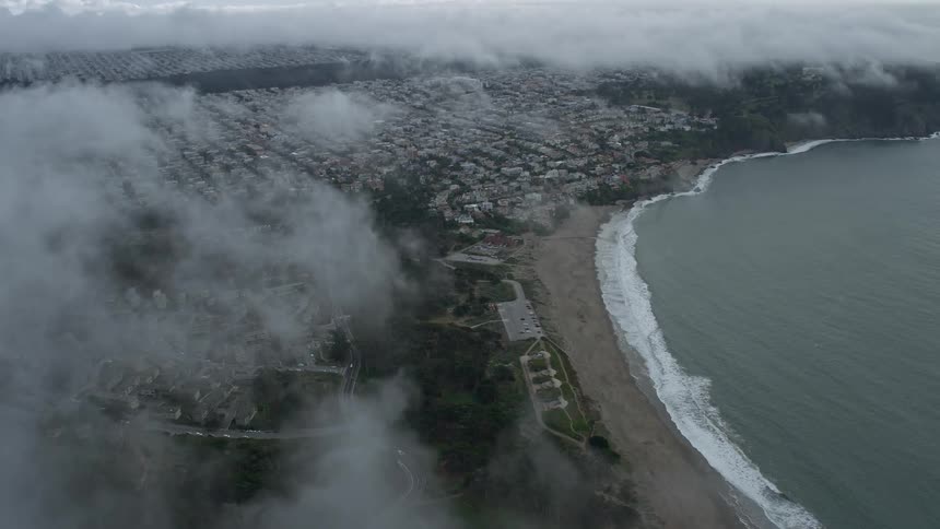 Approaching the Outer Richmond District from Baker Beach San Francisco California with low lying clouds covering portions of the coastal town