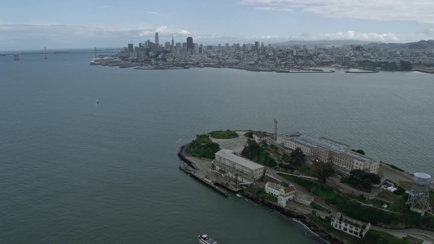 an aerial view of the San Francisco skyline from Alcatraz Island showcasing the city's impressive skyscrapers and downtown area on a cloudy day