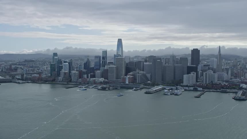 Thisaerial stock footage captures the downtown San Francisco skyline on a cloudy day showcasing the high rise buildings and cityscape of the Bay Area in Northern California