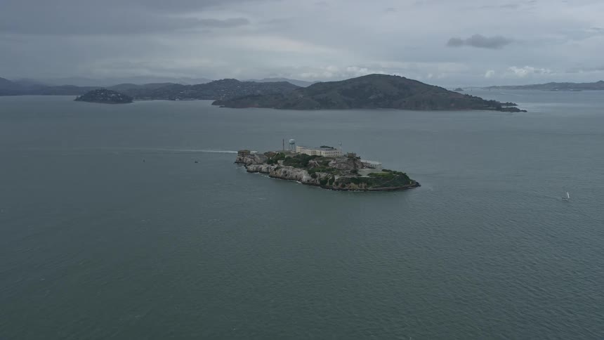 Approaching the historic Alcatraz prison on a cloudy day in San Francisco Bay California with stunning aerial views