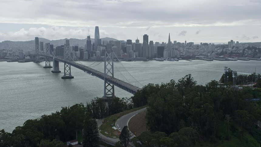 Aerial flyover of Coast Guard pier on Yerba Buena Island revealing Downtown San Francisco skyline California on a cloudy day