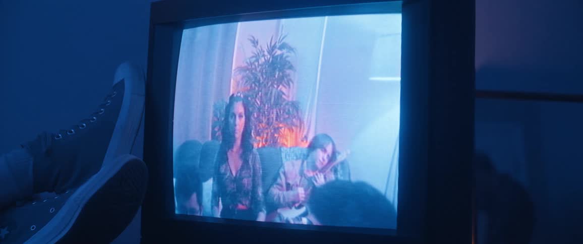 People sitting on sofa appearing on retro television screen