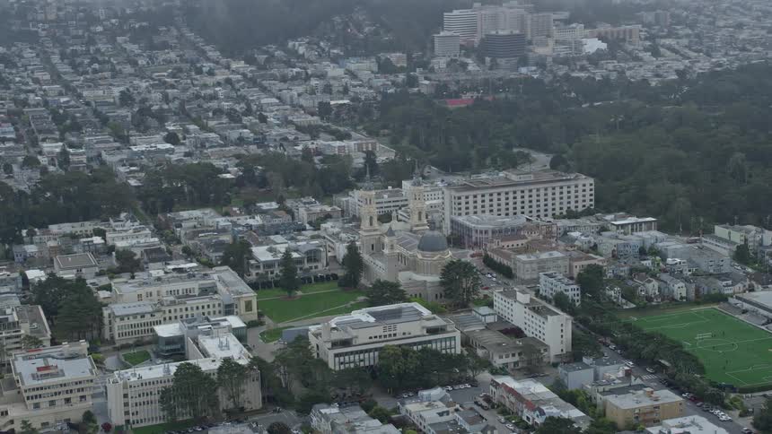 Aerial flyby and approach of St Ignatius Church in the Inner Richmond District San Francisco California showcasing its grandeur and spiritual significance on a foggy day